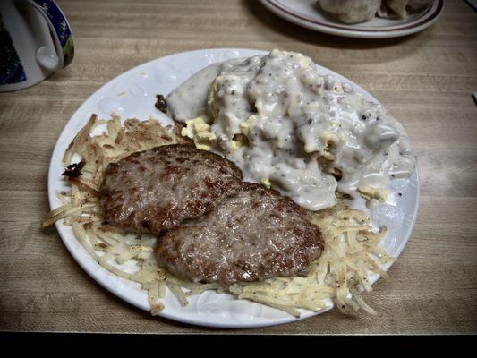 Biscuits & gravy with sausage patties, scrambled eggs, and hash browns.