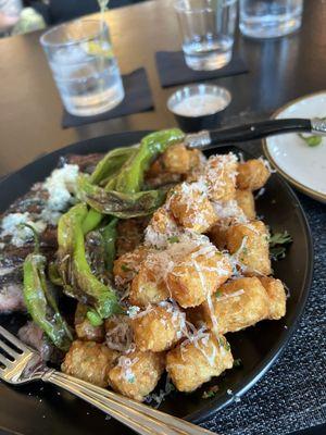 Steak Frittes with shishito peppers and truffle tots