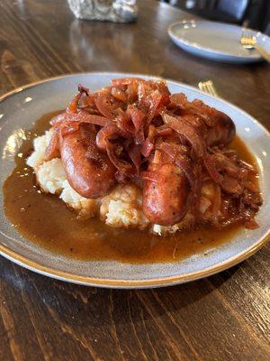 Smoked sausages with mashed potatoes, topped with onion cider gravy