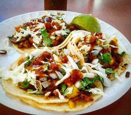 Al Pastor tacos with marinated pork, onions, pineapple, & cilantro.