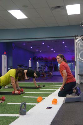 One of our personal trainers working in a small group or semi-private personal training clients at FitMe Wellness, Rockford gym and fitness.