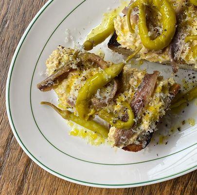 Egg and green olive toast with anchovy and peppers