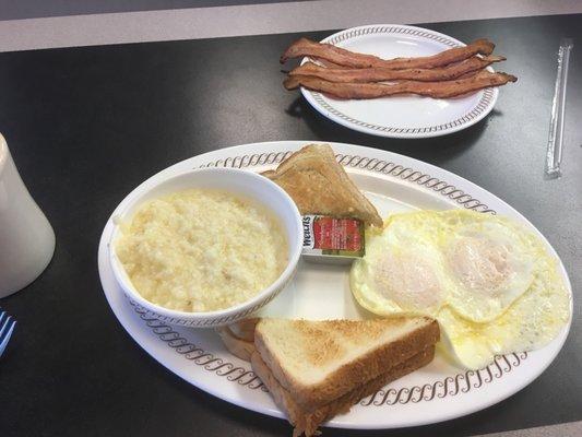 Eggs over medium, grits, bacon, and white toast.