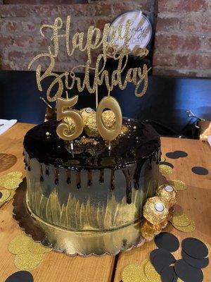 Custom cake for 50th birthday - yellow cake, chocolate filling, buttercream frosting black and gold w/ candy (topper & candles not incld)