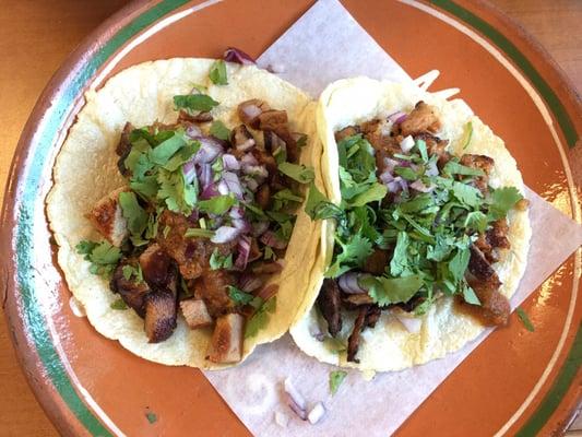 Al Pastor (pork) tacos with onions and cilantro on their homemade tortillas.