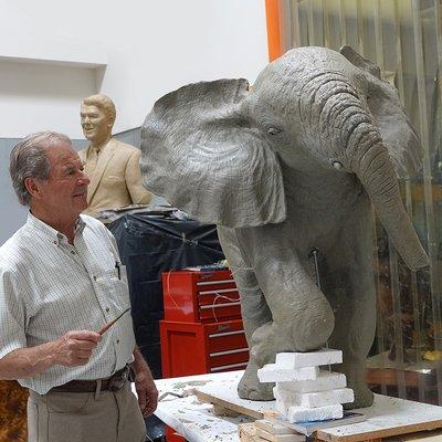 Artist Douglas Van Howd sculpting a life-size baby African elephant in clay.