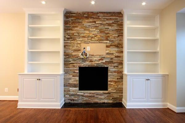 Custom, handcrafted bookcases encase this stone fireplace facade.