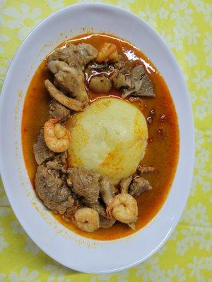 West African-style stew is prepared using an assortment of ingredients such as Smoked fish, shrimp, palm oil, beef, and sometimes goat for a