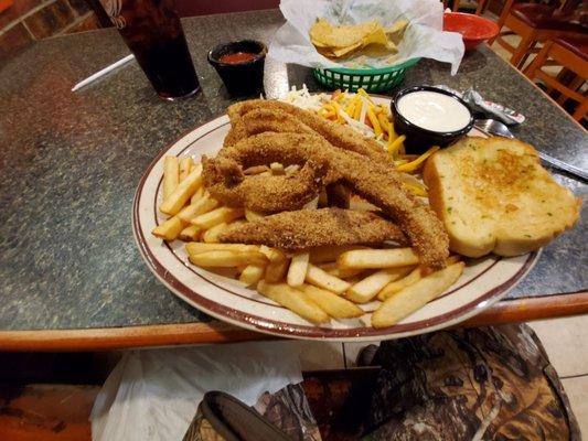 Pre-packaged catfish slivers and garlic toast with under-cooked fries.