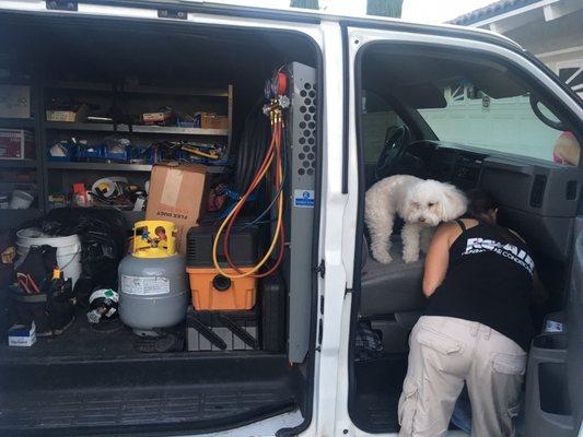 RC air's Cassie digging around in van for some tool she needed to finish our AC installation . Family dog was along for the ride