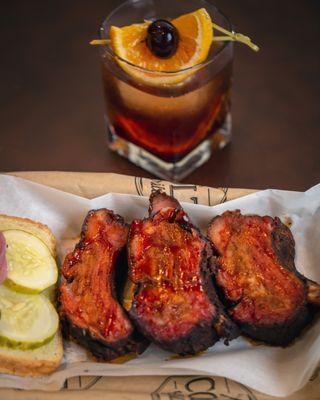 A fabulous COLT fashioned cocktail w/ smoked orange, and 3 juicy baby-back ribs