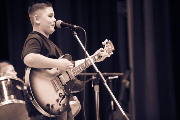 California Guitar Academy student sings and plays guitar.