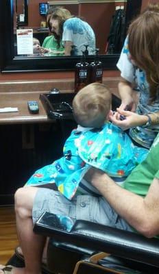 My eight month old baby getting a trim.  Check out his face in the mirror, he loves his stylist.