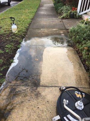 In process of pressure washing a sidewalk.