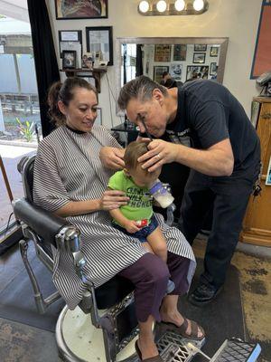 My wife holding my son for his first hair cut.