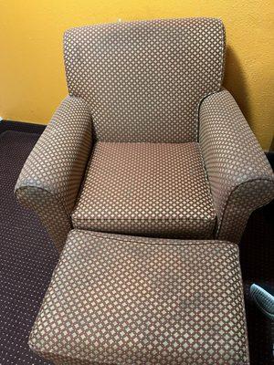 Badly stained chair and ottoman in room