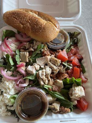 Salad with chicken, old tomatoes , feta cheese, onions, balsamic vinaigrette, bacon. Plus the end slice of a loaf of bread.