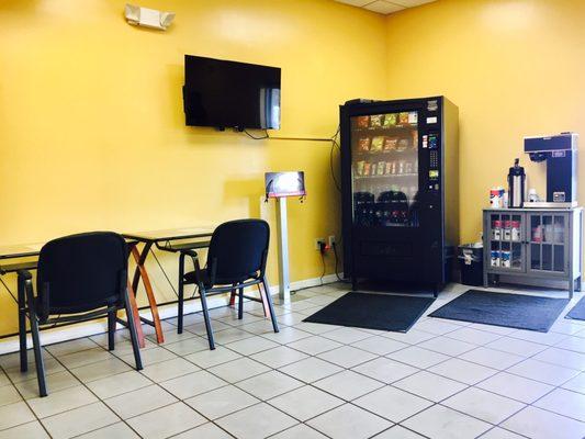 Inside waiting area: coffee, vending machine, tv, charging station to charge electronics and work station.