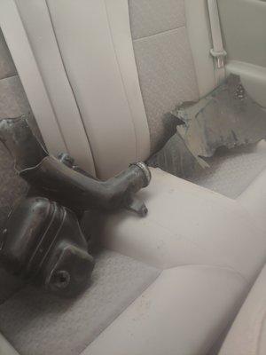 Car pieces thrown into the backseat. The image doesn't show it, but there were oil stains on the fabric.