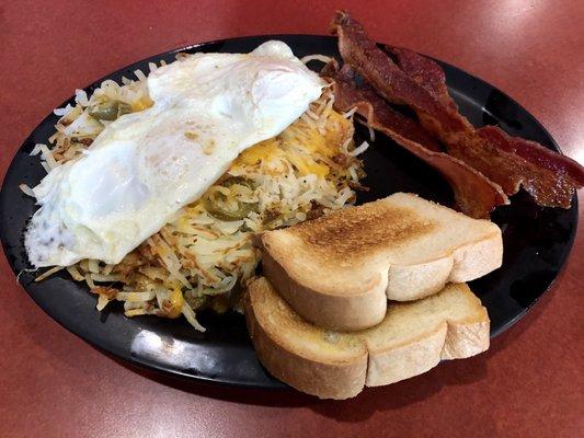 Texas Hash Plate with Texas Hash (hashbrowns, jalapenos, grilled onions, melted cheese) topped with two eggs (over easy), and bacon.