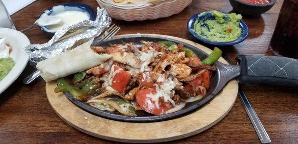 Another special fajitas dinner with bacon and cheese. Small extra queso and guacamole,  partially eaten by me.