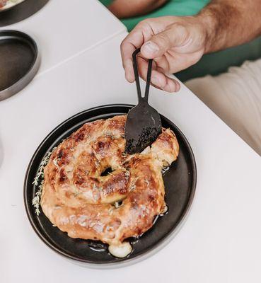 Cutting into a melty and delicious Brie spiral.