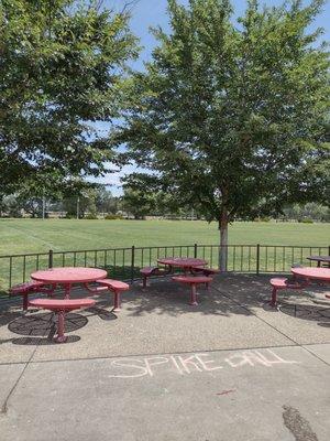 Red tables with a field in the background.