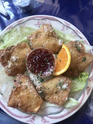 Crab Rangoons served with sweet and sour sauce & an orange.