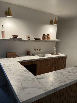 Custom bar installation with solid rift cut white oak.  Wood slats and floating stone shelf.