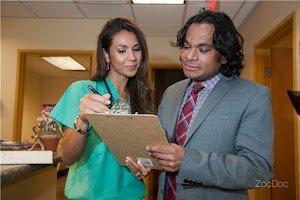 Dr. Khan and his nurse discuss the care plan for a cardiovascular patient in their office.