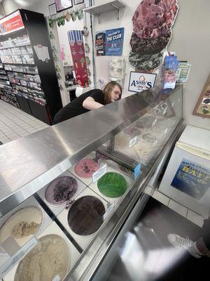 The employee getting down and groovy scooping the ice cream