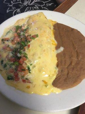 Beef fajitas wrapped in a flour tortilla, covered with Queso, with beans and pico.