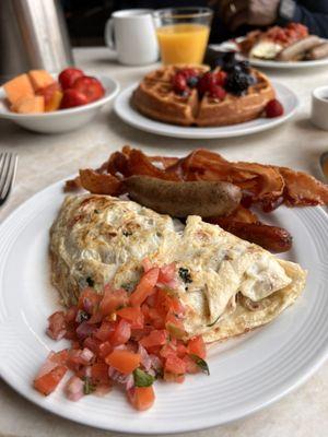 Fresh made omelette and waffle with side of sweet fruit