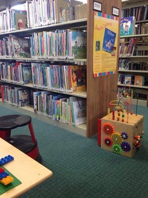 Childrens area has some toys, Legos, and chairs to sit and read.