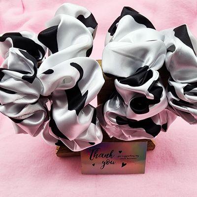 Elevate your hair game with our 'Moo-tiful' Silk Cow Print XXL Scrunchie. This statement piece is a blend of luxury and style