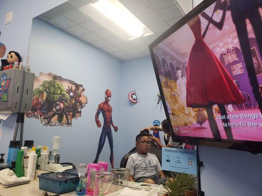 Superhero decorated wall! Clean workspace and TV for the kids to watch.