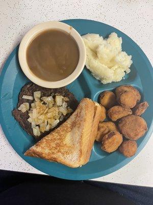 Hamburger steak with mashed potatoes and gravy, Texas toast, and fried squash.