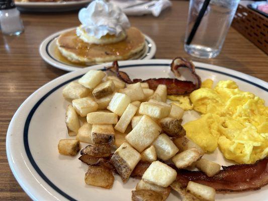 Scrambled eggs, bacon and home fries.