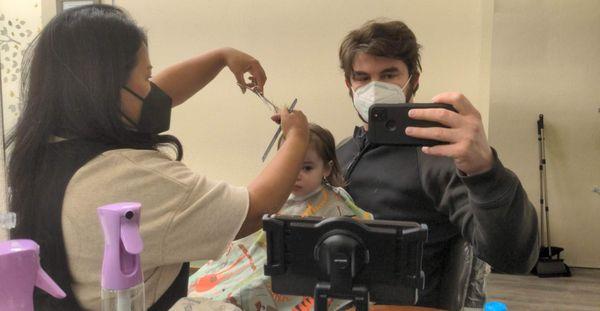 Carmen magically keeping our 19-month-old entertained and calm during her first haircut!