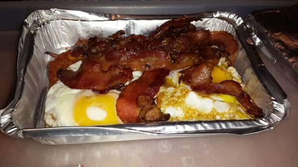 Bacon and eggs with hash browns underneath and texas toast on the side