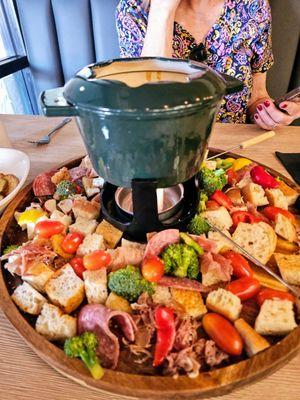 Classic Swiss cheese fondue with all of the goodies.  Bread, vegetables and salami.  Excellent!