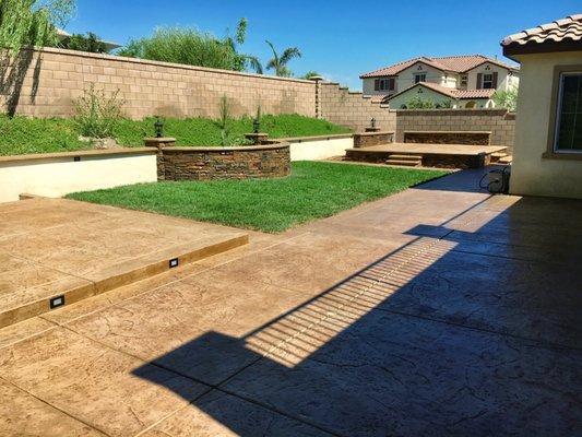 Stamped color concrete, retaining block wall, and raised concrete sitting area