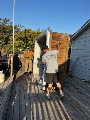 Owner Justin Lynn moving a hot tub.