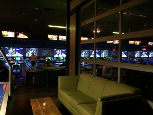 Shot of seating area and the big tv's over the bowling alley.