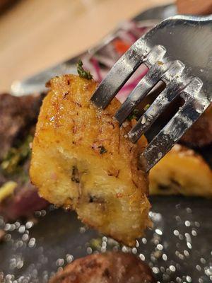 A fork holding a piece of sweet ripe plantain.