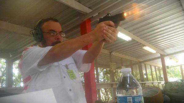 Me shooting my EDC pistol, an M&P Shield Plus 9mm with a Crimson Trace red dot.