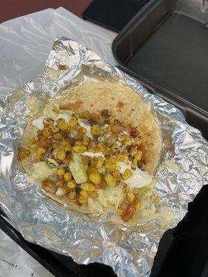 Soft shell beef taco with white American cheese, shredded lettuce, sour cream, and corn salsa