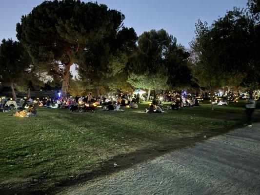 Some of the people sitting out by the lake prepping their lanterns