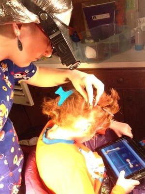 LiceDoctors technician checks for lice and nits (eggs) in her client's hair.