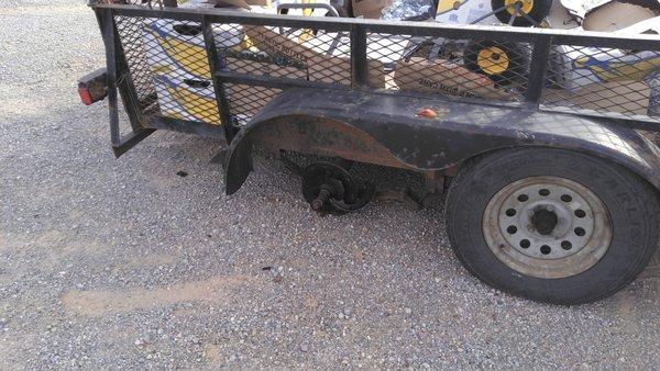 Old trailer with broken wheel and axle.